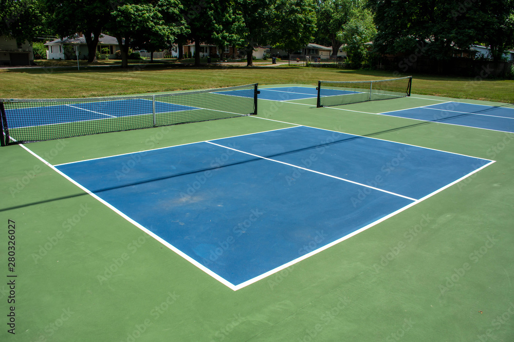 Recreational sport of pickleball court in Michigan, USA looking at an empty blue and green new court at a outdoor park.