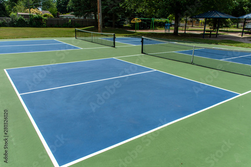 Recreational sport of pickleball court in Michigan, USA looking at an empty blue and green new court at a outdoor park. © KingmaPhotos