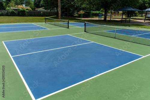 Recreational sport of pickleball court in Michigan, USA looking at an empty blue and green new court at a outdoor park.