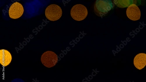 Yellow lights flash along an airport runway at night, marking the boundary between the taxiway and runway. The lights are shown as defocused bokeh. photo