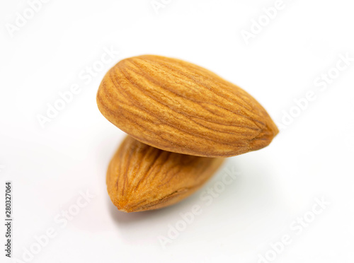 Two almond seeds stacked on a white background.