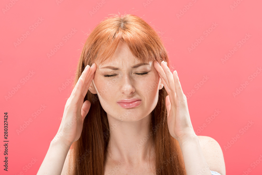 front view of redhead young woman with headache touching head isolated on pink front view of redhead young woman with headache touching head isolated on pink
