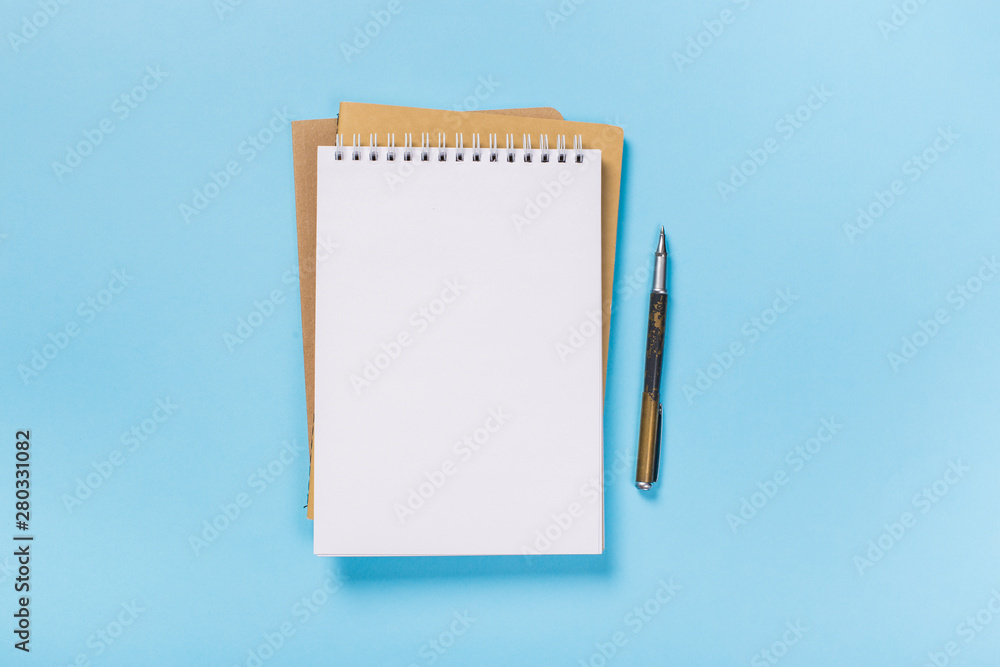 school notebook on a blue background, spiral notepad on a table school notebook on a blue background, spiral notepad on a table