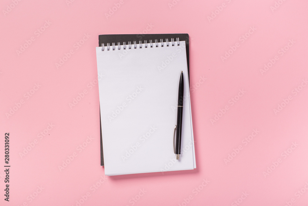 school notebook on a pink background, spiral notepad on a table. school notebook on a pink background, spiral notepad on a table.