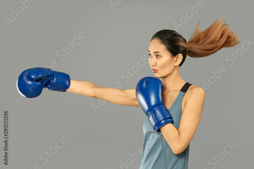 Female Asian boxer on grey ...