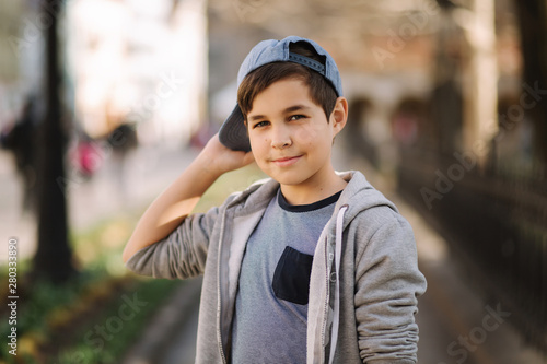 Portrait of little boy in cap. Stylish boy walking in the city