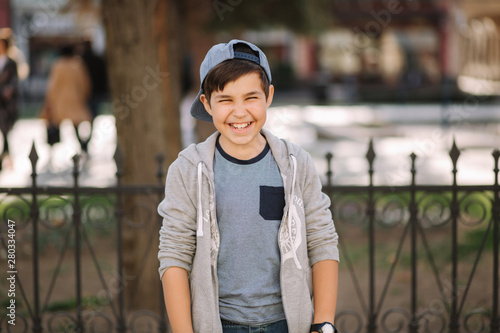 Cute boy walking in the city. Stylish teenage boy outside