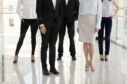 Feet of diverse employees or managers standing in office hallway