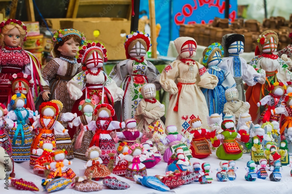 set of handmade textile human rag dolls, Ukrainian ethnic traditional toy symbol motanka, folk craft souvenir, art embroidery on canvas, on sale at ethno festival fair