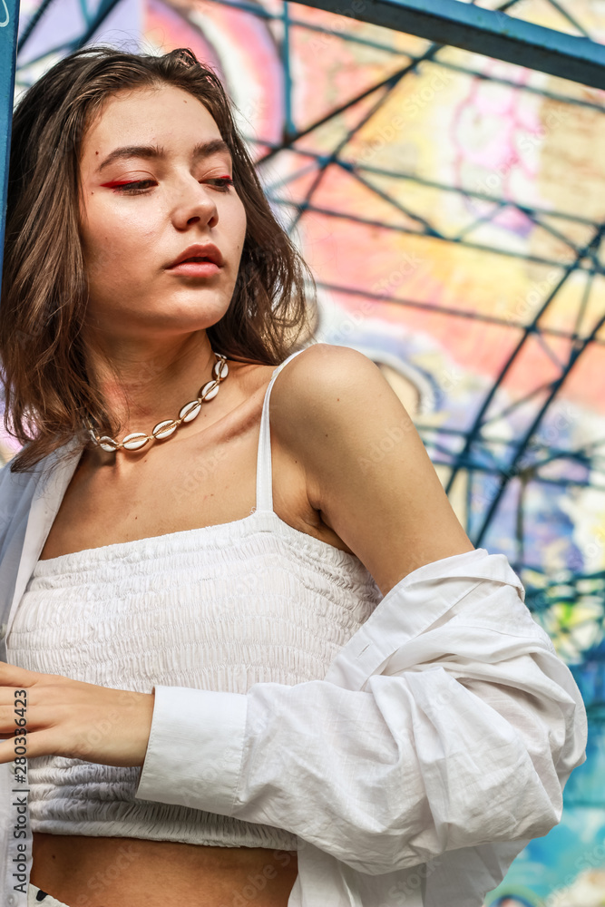Fototapeta premium Young beautiful lady wearing a stylish white top.Portrait shooting of a stylish girl.Trends summer 2019.