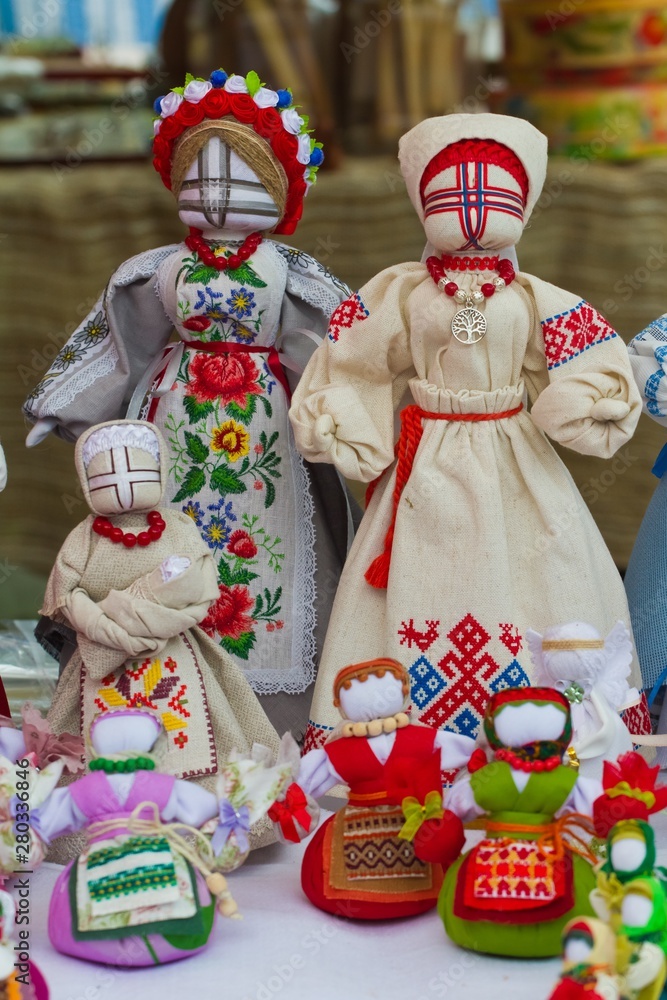 set of handmade textile human rag dolls, Ukrainian ethnic traditional toy symbol motanka, folk craft souvenir, art embroidery on canvas, on sale at ethno festival fair