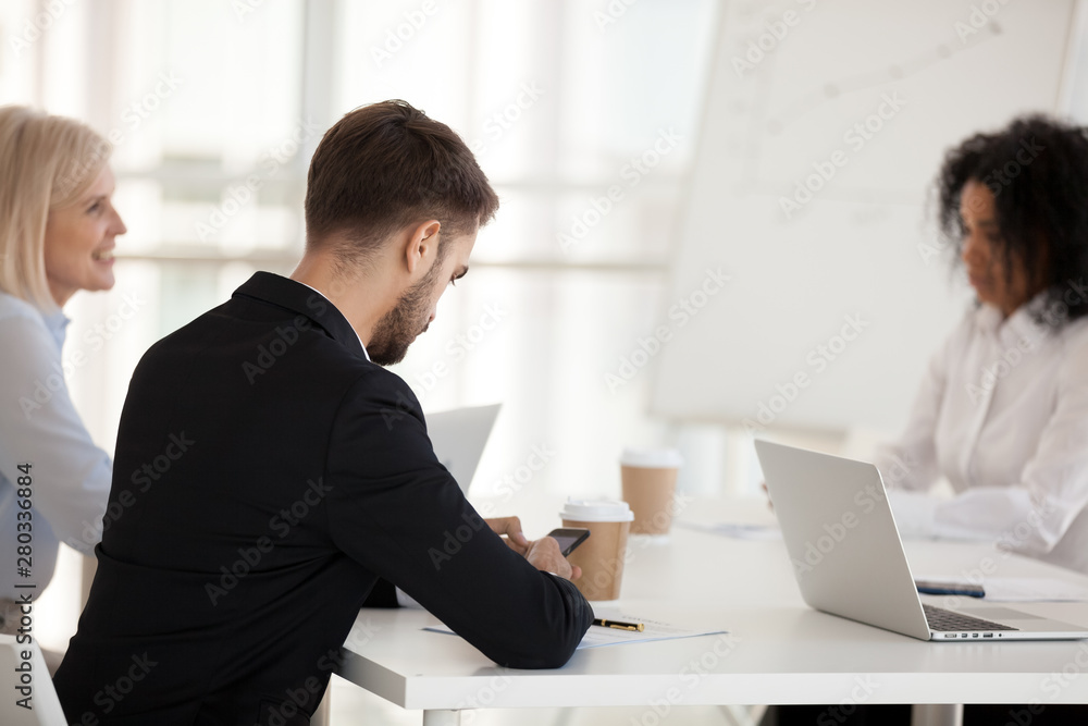 Businesswoman using phone at company meeting rear view Businesswoman using phone at company meeting rear view