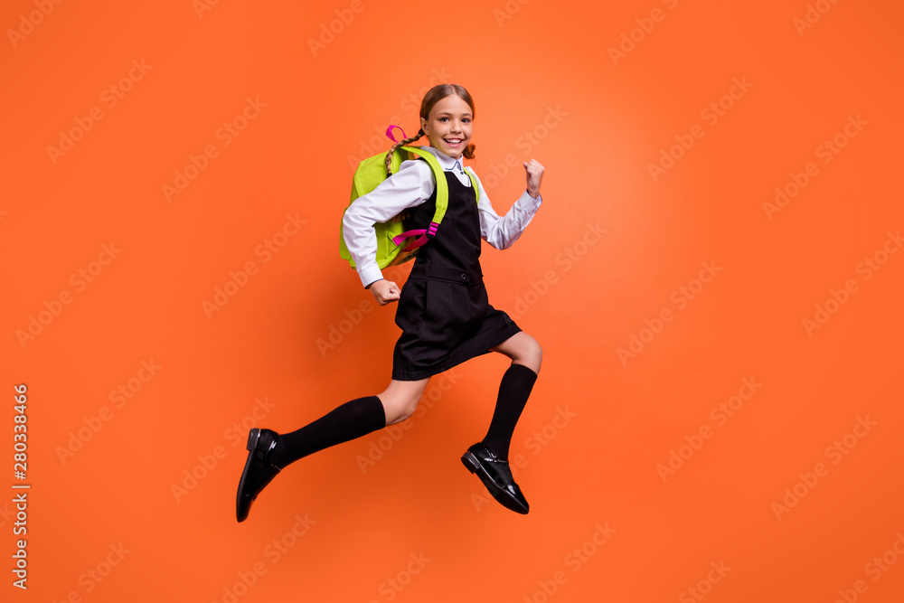 Full length body size view of nice attractive lovely cheerful cheery glad diligent pre-teen girl nerd running fast first grade back to school isolated on bright vivid shine orange background