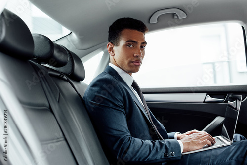 handsome african american businessman using laptop in car © LIGHTFIELD STUDIOS