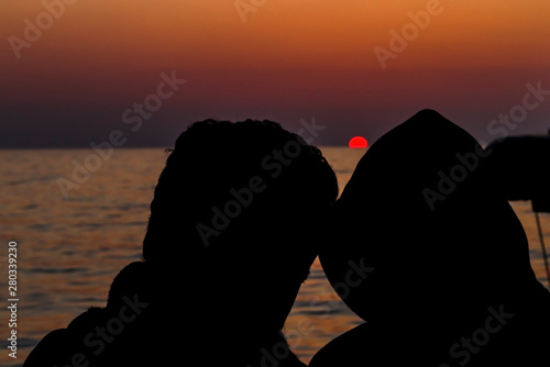 Silhouette romantic couple in love hugs watching the sunset.