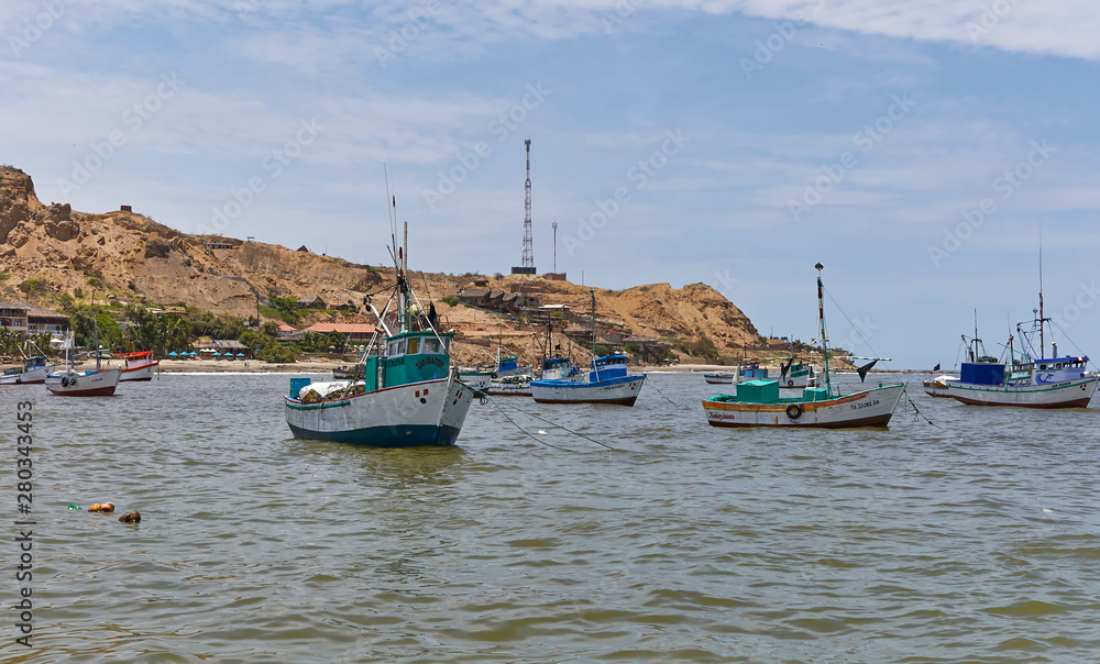 Heading out between the anchored Fishing Fleet of Wooden Boats moored just off Mancora Beach in Peru, South America. Heading out between the anchored Fishing Fleet of Wooden Boats moored just off Mancora Beach in Peru, South America.