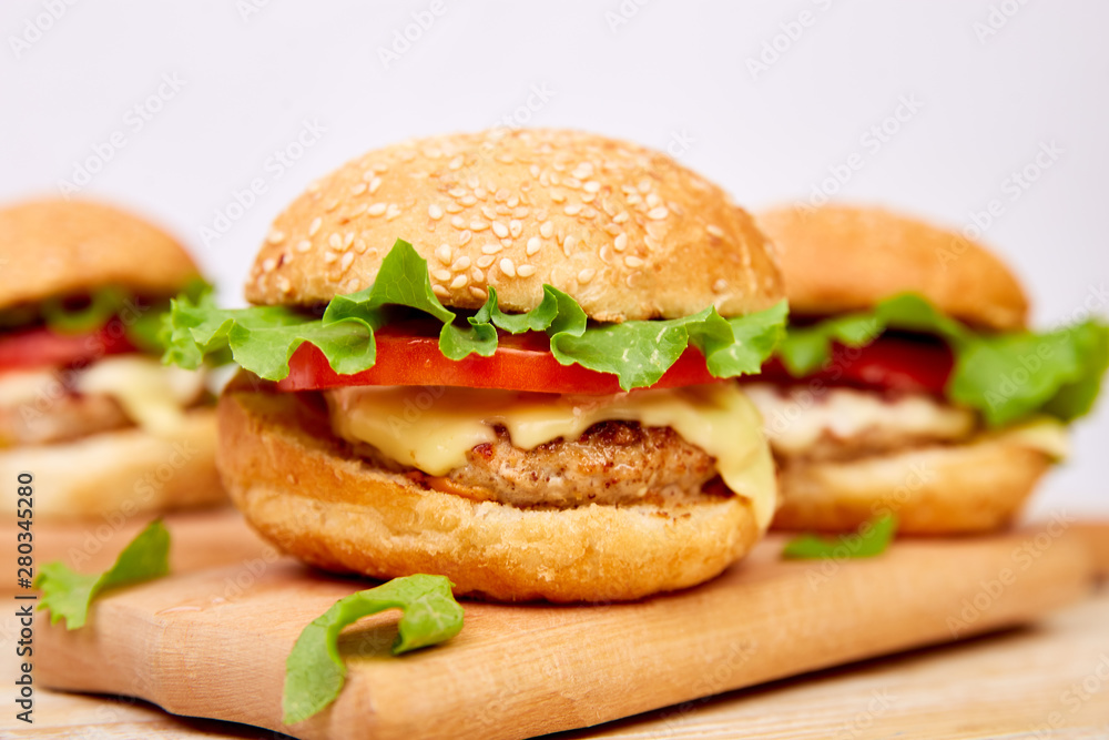 Craft beef burger on wooden table on light background. Street food, fast food. Homemade juicy burgers with cheese and on the wooden table. Copy space. Craft beef burger on wooden table on light background. Street food, fast food. Homemade juicy burgers with cheese and on the wooden table. Copy space.