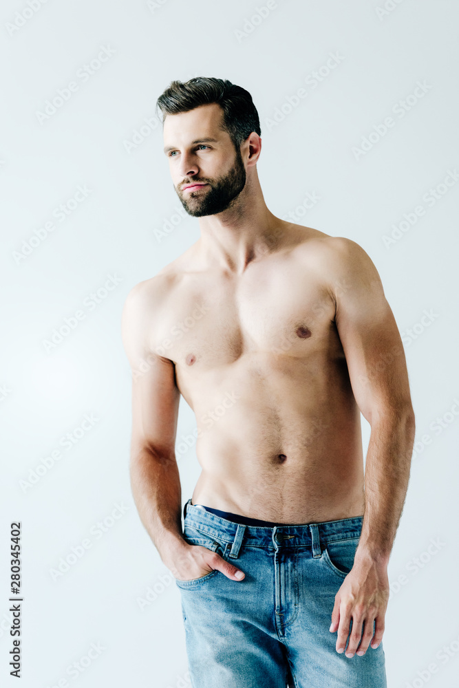 shirtless handsome man in jeans posing with hand in pocket on grey