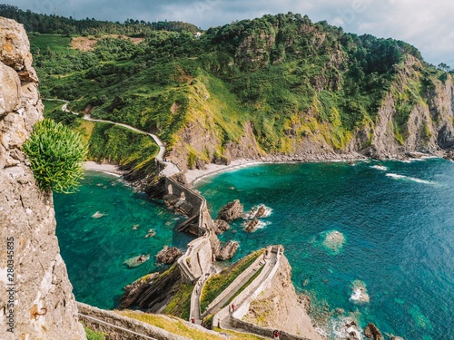 Picturesque picturesque road winding stairs to the island Gaztelugatxe on the coast of the Bay of Biscay and looks at the mountain. Spain, Basque Country photo