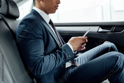 partial view of african american businessman using smartphone in car © LIGHTFIELD STUDIOS