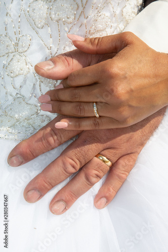 bride and groom marriage holding hands with wedding rings in white dress background