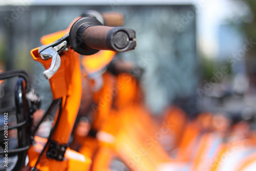 Orange bike handle with more bikes in the background