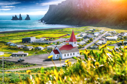 Tableau sur toile Beautiful view of Vikurkirkja christian church in blooming flowers