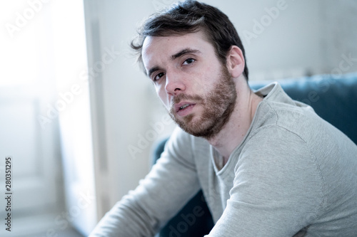 Young man suffering from depression hopeless and alone at home