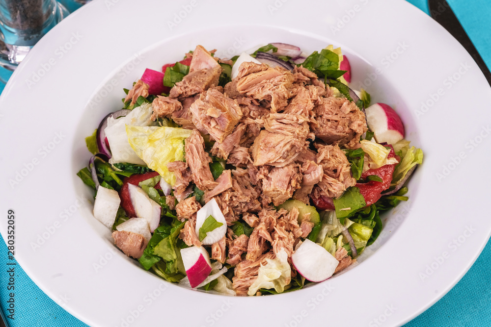 Seafood, Mediterranean cuisine. Salad from sea tuna fish with greens, cucumber, lemon and chili pepper, radish. Japanese food Seafood, Mediterranean cuisine. Salad from sea tuna fish with greens, cucumber, lemon and chili pepper, radish. Japanese food