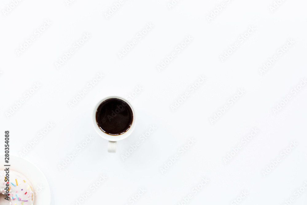 donut and black coffee with copy space. Cup of black coffee with donut on a plate on white table, top view, flat lay. Delicious breakfast. donut and black coffee with copy space. Cup of black coffee with donut on a plate on white table, top view, flat lay. Delicious breakfast.