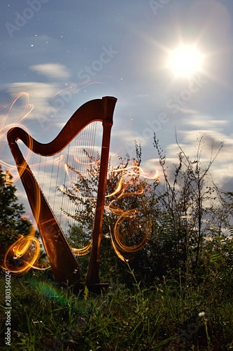 Harpe de nuit et light painting feu - instrument de musique - lumière lune  photo