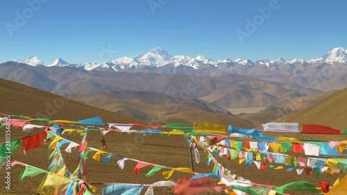 SLOW MOTION, CLOSE UP: Colorful buddhist prayer flags flutter in the desert leading to Mount Everest. Cinematic shot of multicolored pieces of cloth flapping in winds blowing across Tibetan plains.