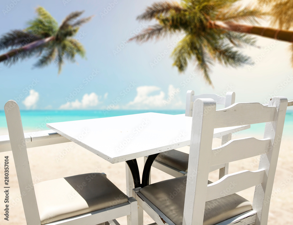 Table background with beautiful blue ocean and sandy beach view in distance.