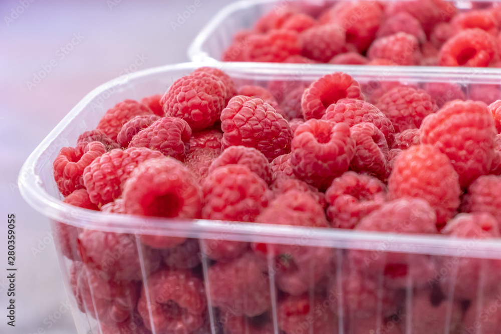 Pile of raw beautiful raspberries at plastic container. texture, backdrop. fresh dessert berries. Pile of raw beautiful raspberries at plastic container. texture, backdrop. fresh dessert berries.