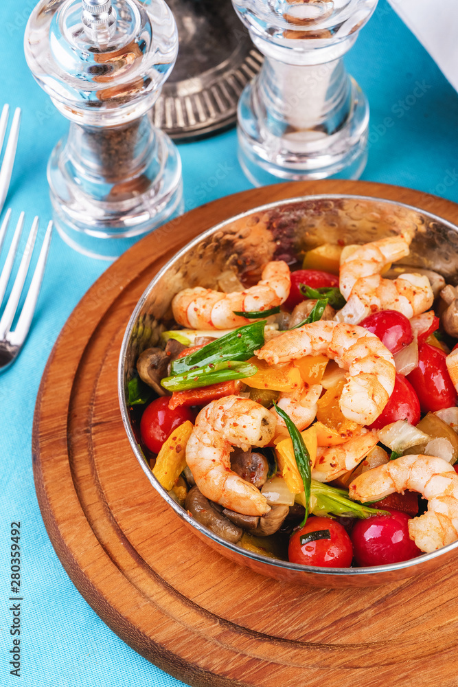 Seafood, Mediterranean cuisine, European dish. Warm salad of grilled fish pieces, shrimps and mussels in a frying pan, with grilled vegetables - with green onions, greens, mushrooms and vegetables. Seafood, Mediterranean cuisine, European dish. Warm salad of grilled fish pieces, shrimps and mussels in a frying pan, with grilled vegetables - with green onions, greens, mushrooms and vegetables.