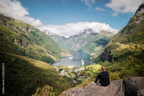 male hiker with view over geiranger fjord from flydalsjuvet photo