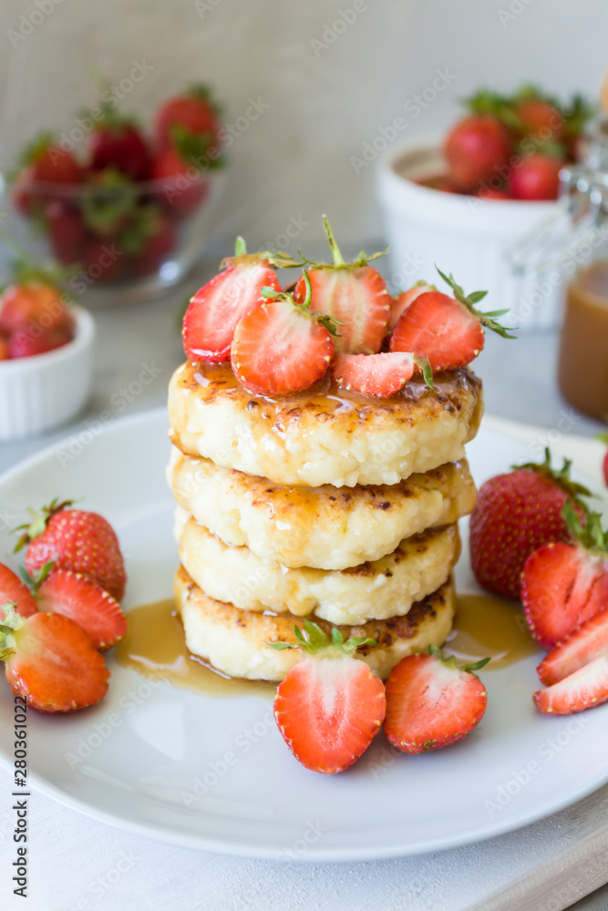 Cottage cheese pancakes syrniki with strawberries and honey. The concept of tasty healthy summer Breakfast. Copy space, side view.
