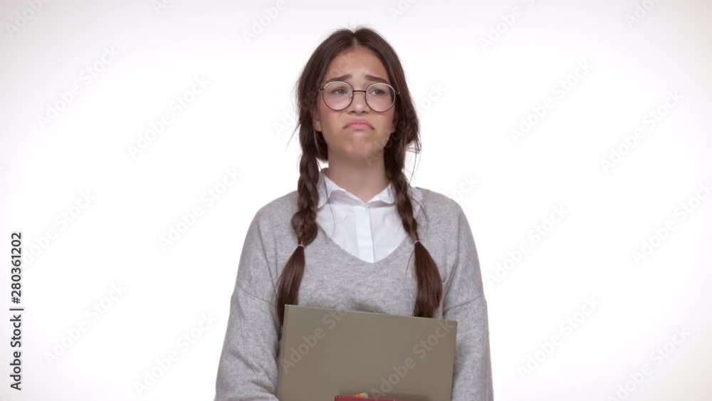 Attractive young brunette girl student with books feeling tired and sad while looking at the camera over white background isolated Attractive young brunette girl student with books feeling tired and sad while looking at the camera over white background isolated