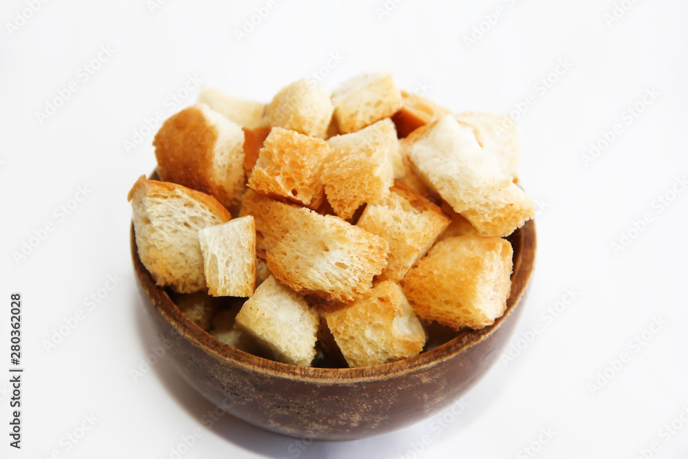 fried dry white bread crackers in a wooden plate on a white background fried dry white bread crackers in a wooden plate on a white background