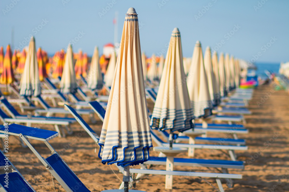 Beach in Rimini, Italy. Umbrellas on sandy beach in resort city Rimini on sunny morning