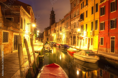Venice cityscape at night. Italian Venice in the evening. Venetian canal with boats at night. Beautiful view on down town of Venice. Venice illuminated by citylights