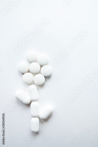 White flower-shaped capsules isolated on white background, copyspace for text, selective focus, top view. Pain drugs, health, pills for the treatment of the concept of addiction