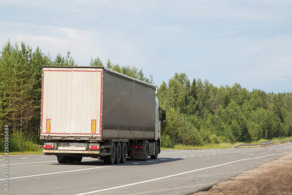 Cargo trailer in the summer goes on the highway.