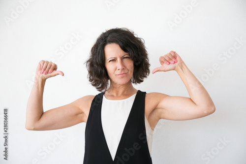 Positive confident woman proud of herself. Arrogant middle aged woman pointing thumbs at herself. Self pride concept