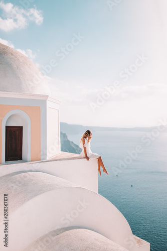 Fototapeta Naklejka Na Ścianę i Meble -  woman sitting on rooftop in Santorini