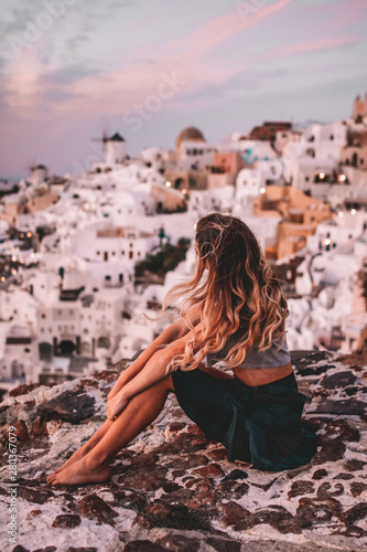 Woman during sunset from viewpoint over Oia, Santorini © Mathilda
