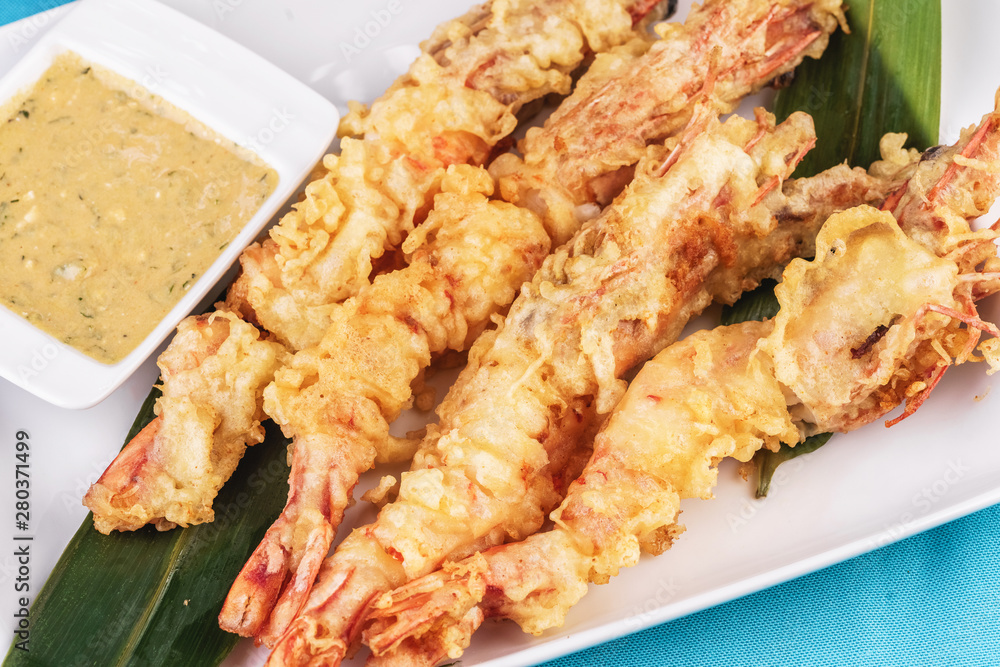 European cuisine, Mediterranean dish. Whole prawns fried in butter and batter snack for beer with cream-mustard sauce European cuisine, Mediterranean dish. Whole prawns fried in butter and batter snack for beer with cream-mustard sauce