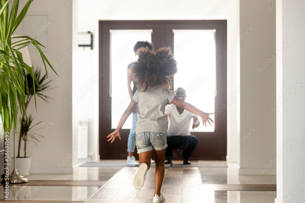 African little daughter running to parents who standing in doorway African little daughter running to parents who standing in doorway