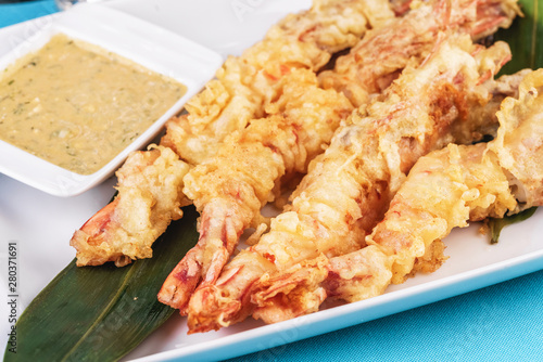 European cuisine, Mediterranean dish. Whole prawns fried in butter and batter snack for beer with cream-mustard sauce