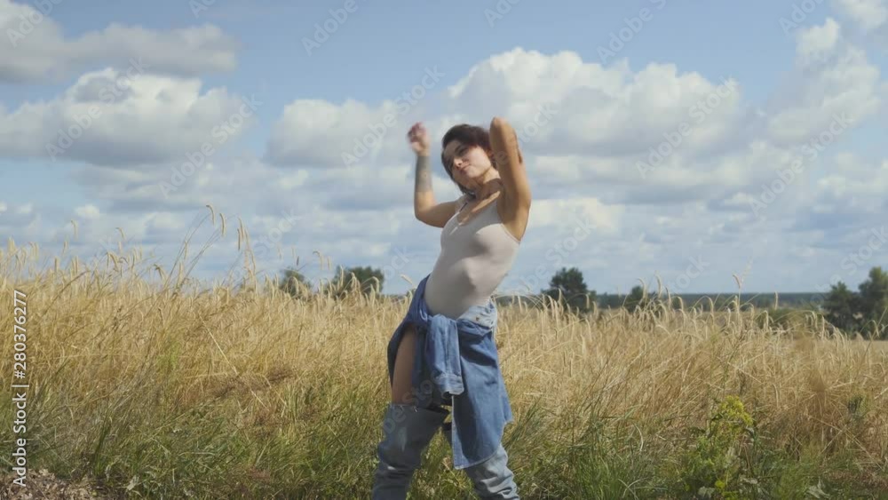 Cute woman with short hair wearing bodysuit relaxing on the wheat field. Girl enjoys nature looking and posing at the camera. Confident carefree girl outdoors. Real people series Cute woman with short hair wearing bodysuit relaxing on the wheat field. Girl enjoys nature looking and posing at the camera. Confident carefree girl outdoors. Real people series